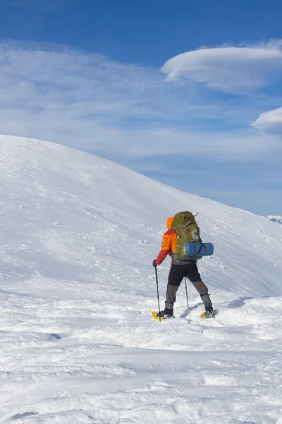 Winter hiking in the mountains on snowshoes with a backpack and tent. — Stock Photo, Image