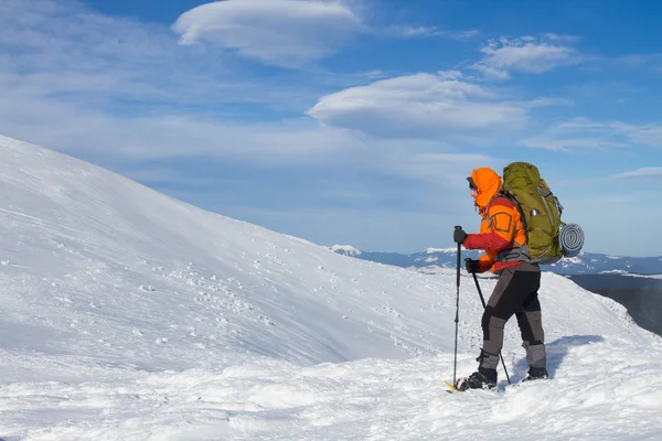 Caminhadas de inverno nas montanhas em sapatos de neve com uma mochila e tenda . — Fotografia de Stock