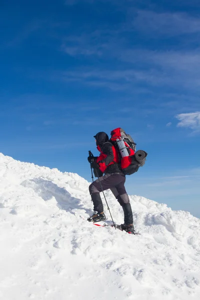 Caminhadas de inverno nas montanhas em sapatos de neve com uma mochila e tenda . — Fotografia de Stock