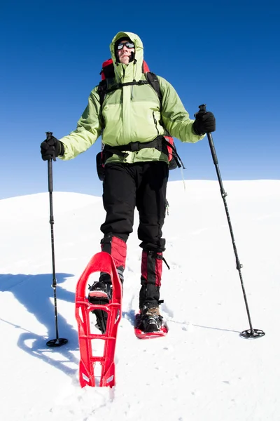 Winter hiking in the mountains on snowshoes with a backpack and tent. — Stock Photo, Image