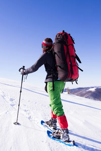 Caminhadas de inverno nas montanhas em sapatos de neve com uma mochila e tenda . — Fotografia de Stock