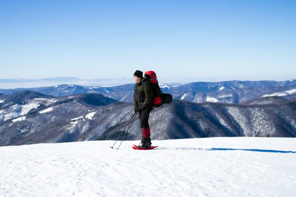 冬のバックパック、テント、スノーシューで山でのハイキング. — ストック写真