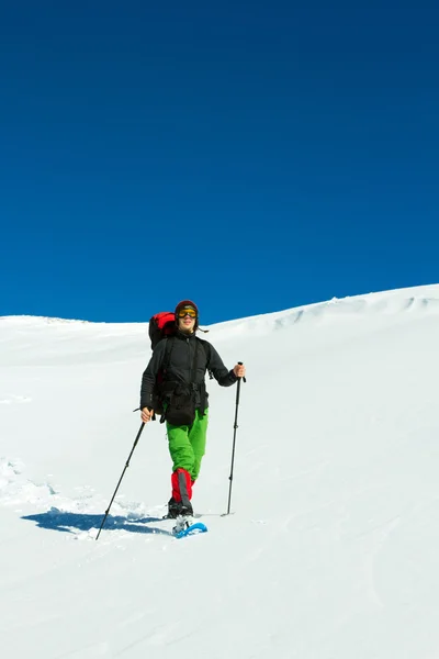 Escursioni invernali in montagna con le ciaspole con zaino e tenda . — Foto Stock