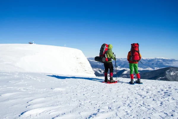 Winter wandelen in de bergen op sneeuwschoenen met een rugzak en tent. — Stockfoto