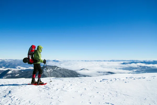 Winter wandelen in de bergen op sneeuwschoenen met een rugzak en tent. — Stockfoto