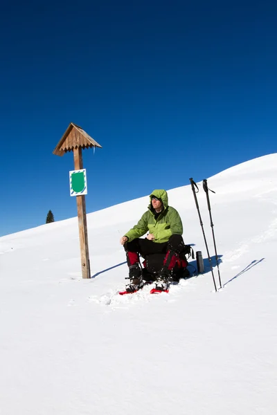 Caminhadas de inverno nas montanhas em sapatos de neve com uma mochila e tenda . — Fotografia de Stock