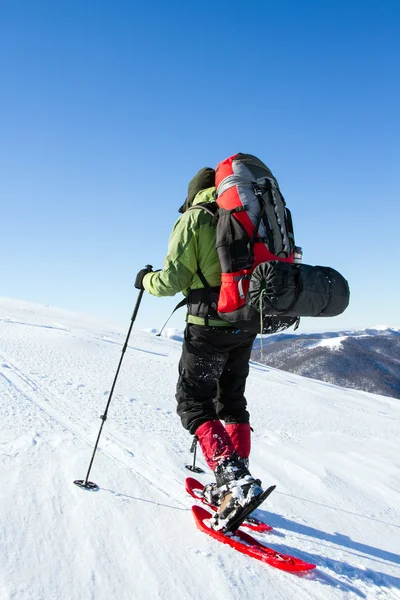 Dağlarda kar ayakkabıları bir sırt çantası ve çadır hiking kış. — Stok fotoğraf