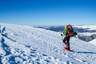 Dağlarda kar ayakkabıları bir sırt çantası ve çadır hiking kış.