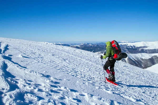 在山里徒步旅行带着背包和帐篷雪的冬天. — 图库照片