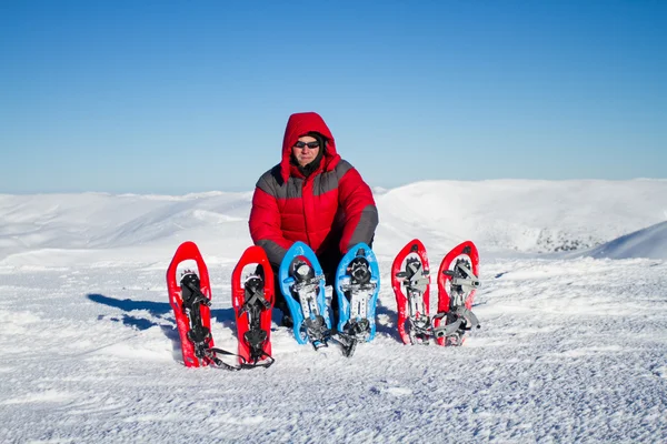 Vinter vandring i bergen på snöskor med en ryggsäck och tält. — Stockfoto