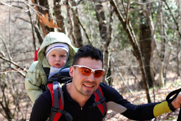 Father is hiking with the 1.5 year baby in baby carrier — Stock Photo, Image