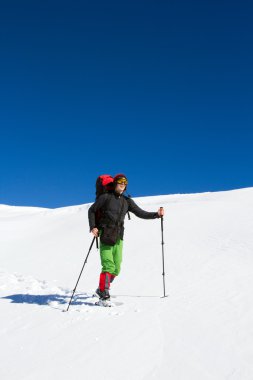 Dağlarda kar ayakkabıları bir sırt çantası ve çadır hiking kış.