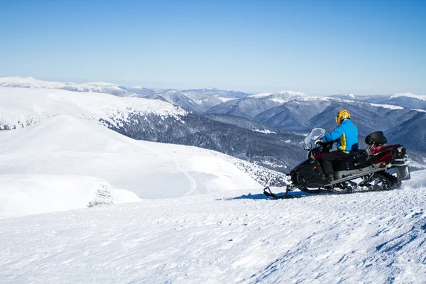 Homme en motoneige en montagne hivernale — Photo