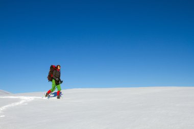 Dağlarda kar ayakkabıları bir sırt çantası ve çadır hiking kış.
