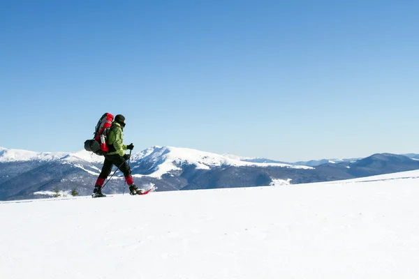 Randonnée hivernale en montagne en raquettes avec sac à dos et tente . — Photo