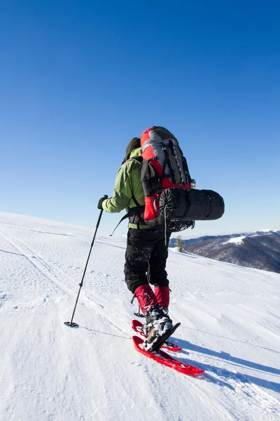 在山里徒步旅行带着背包和帐篷雪的冬天. — 图库照片