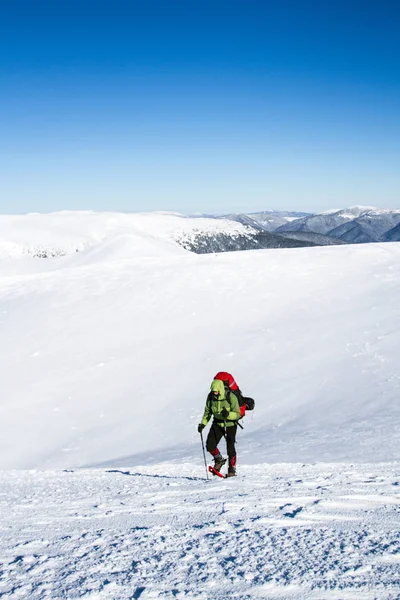 Winter wandelen in de bergen op sneeuwschoenen met een rugzak en tent. — Stockfoto