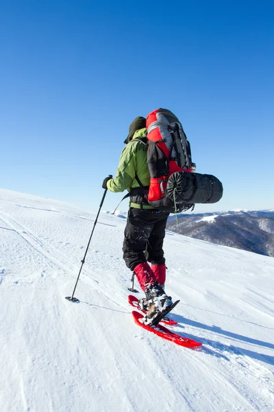 在山里徒步旅行带着背包和帐篷雪的冬天. — 图库照片