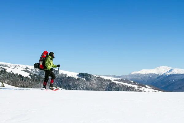 Randonnée hivernale en montagne en raquettes avec sac à dos et tente . — Photo