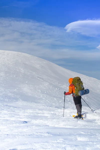 Winter wandelen in de bergen op sneeuwschoenen met een rugzak en tent. — Stockfoto