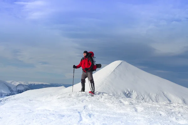 Caminhadas de inverno nas montanhas em sapatos de neve com uma mochila e tenda . — Fotografia de Stock