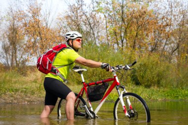 crossing kayalık arazi onun elinde bisiklet ile genç atlet.