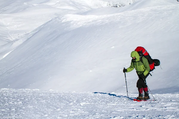 Caminhadas de inverno nas montanhas em sapatos de neve . — Fotografia de Stock