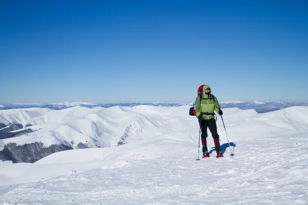 Senderismo de invierno en las montañas en raquetas de nieve . — Foto de Stock