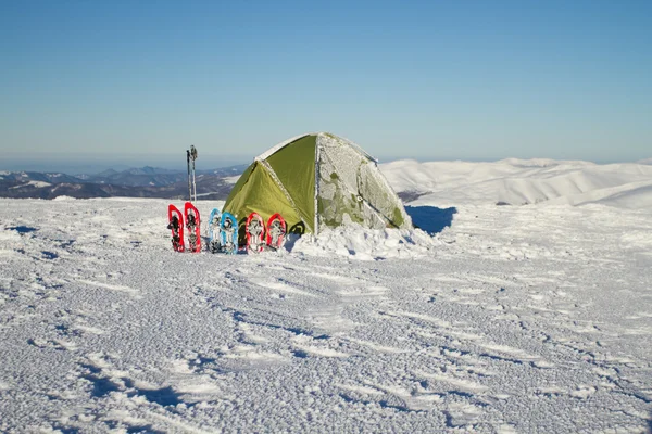 Tent winter mountains.Tent stands in the mountains in the snow. Snowshoes are beside the tent. — Stock Photo, Image