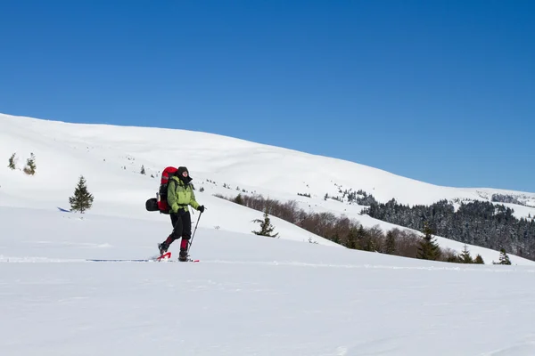 在山里徒步旅行带着背包和帐篷雪的冬天. — 图库照片