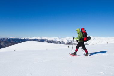 Dağlarda kar ayakkabıları bir sırt çantası ve çadır hiking kış.
