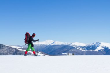 Dağlarda kar ayakkabıları bir sırt çantası ve çadır hiking kış.