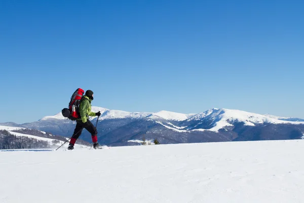 Winter hiking in the mountains on snowshoes with a backpack and tent. — Stock Photo, Image