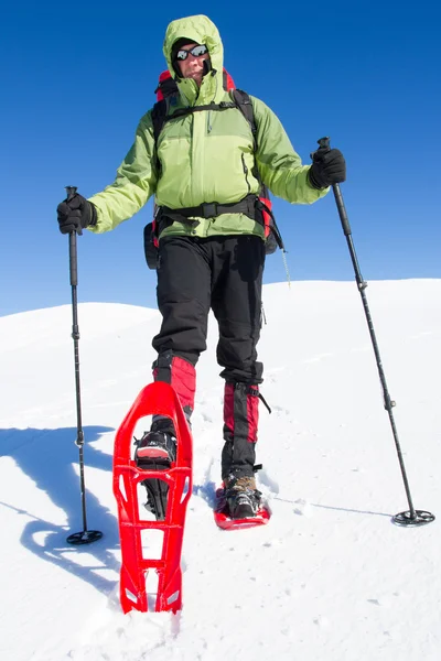 Winter wandelen in de bergen op sneeuwschoenen met een rugzak en tent. — Stockfoto