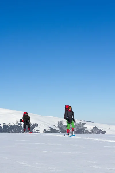 在山里徒步旅行带着背包和帐篷雪的冬天. — 图库照片