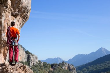 kaya tırmanışçısı kayalık bir duvara tırmanıyor.