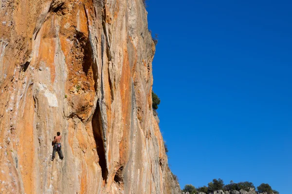 Szikla mászó mászik egy sziklás falon. — Stock Fotó