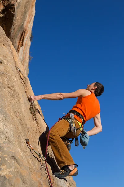 Rock klimmer klimt op een rotsachtige muur. — Stockfoto