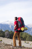 Wanderer mit Rucksack genießen Talblick von der Bergspitze