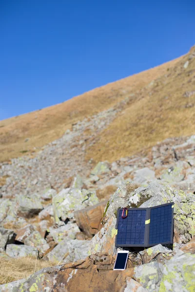 Solární panel. Solární panel připojený ke stanu. Muž vedle mobilních telefonů poplatky od slunce. — Stock fotografie