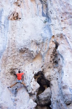 Uçurumun kenarında asılı genç bir tırmanıcı.
