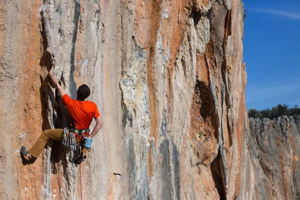 Young male climber hanging by a cliff. — Stock Photo, Image