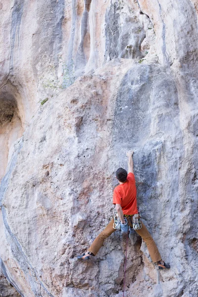 Junger männlicher Kletterer hängt an einer Klippe. — Stockfoto