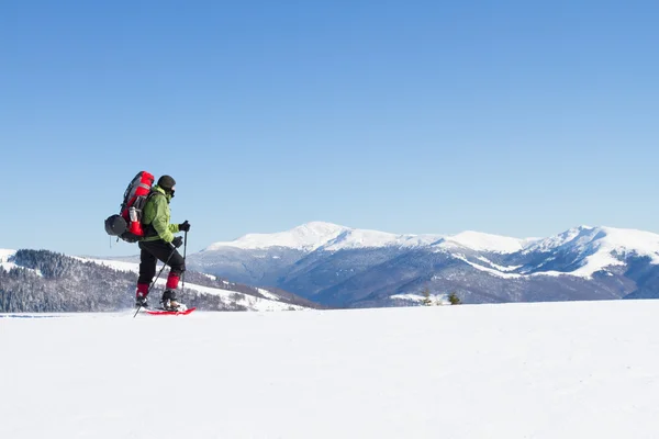 Winterwandern in den Bergen auf Schneeschuhen mit Rucksack und Zelt. — Stockfoto