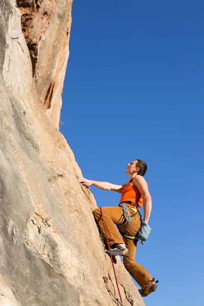 Junger männlicher Kletterer hängt an einer Klippe. — Stockfoto