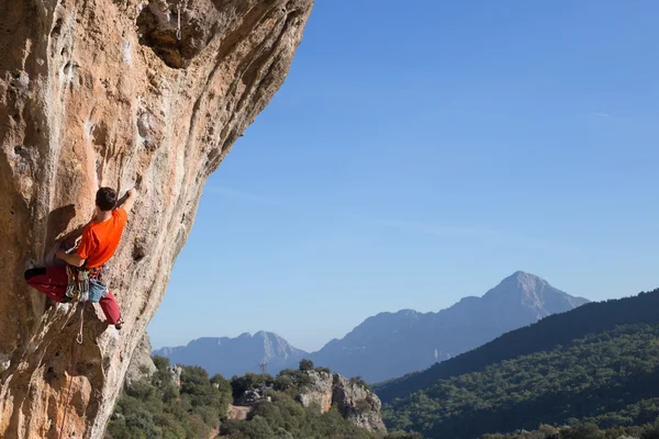 Junger männlicher Kletterer hängt an einer Klippe. — Stockfoto