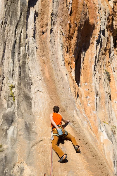 Jovem alpinista pendurado por um penhasco. — Fotografia de Stock