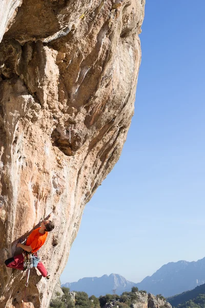 崖にぶら下がっている若い男性登山家. — ストック写真