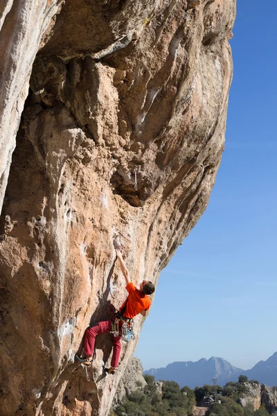 Jonge mannelijke klimmer opknoping door een klif. — Stockfoto