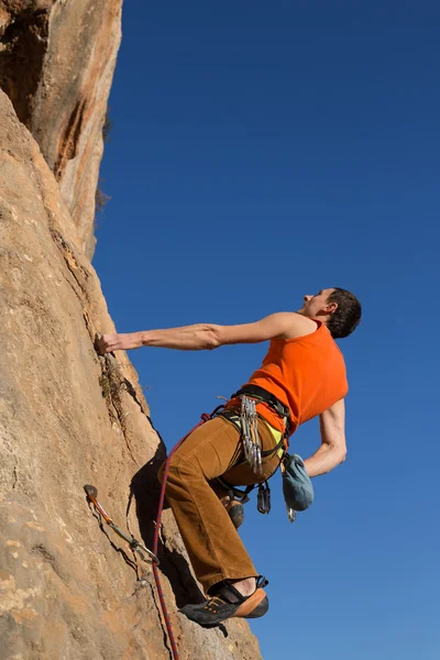 Junger männlicher Kletterer hängt an einer Klippe. — Stockfoto